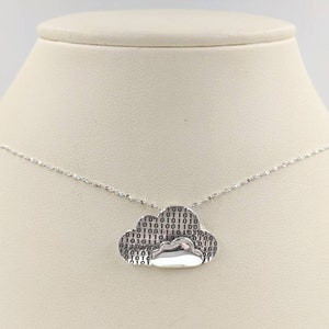 May include: A silver necklace with a cloud pendant. The cloud is textured with a pattern of binary code.