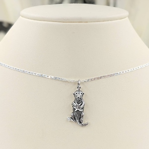 May include: A silver necklace with a silver otter charm. The otter is holding a starfish in its paws.