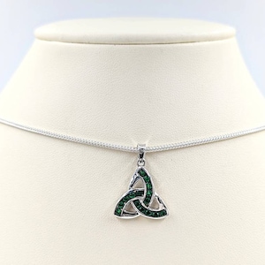 May include: A silver necklace with a green crystal Celtic knot pendant. The pendant is a traditional Irish symbol of love, friendship, and loyalty.