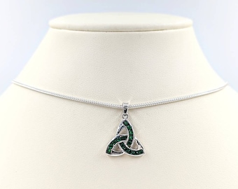 Può includere: Una collana d'argento con un ciondolo a nodo celtico in cristallo verde. Il ciondolo è un simbolo tradizionale irlandese di amore, amicizia e lealtà.