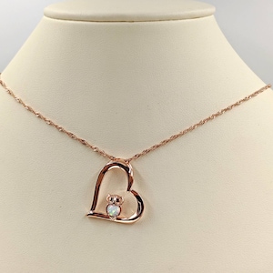 Könnte beinhalten: Eine Halskette aus Roségold mit einem herzförmigen Anhänger, der eine kleine Eule mit einem Opal-Edelstein zeigt.