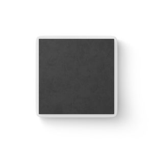 Shows the back of a square white magnet almost entirely covered by black magnetic material.
