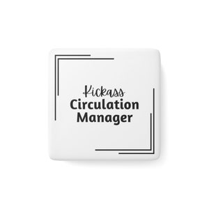 Square white porcelain magnet with text that reads Kickass [italics] Circulation Manager [non-italics] with double corner brackets in the upper left and lower right corners. Magnet is on a plain white background.