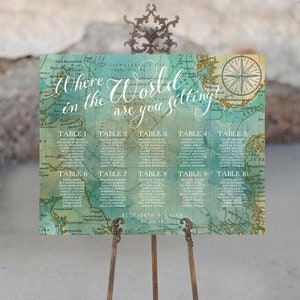 May include: A vintage world map seating chart for a wedding reception. The map is printed on a light blue background with a green watercolor wash. The chart is titled "Where in the world are you sitting?" and lists guest names by table number.