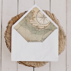 May include: A white envelope liner with a vintage map design featuring a compass and the text "Stavanger Taderens C Ekersund Lister Pj Christiansand Lister Manda Lindesnas Ska R Hans Kho Kl. Fischer".