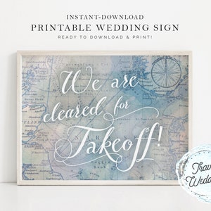 Könnte beinhalten: Druckbarer Hochzeitsschild mit einem Vintage-Kartenhintergrund und dem Text "We are cleared for takeoff!" in weißer Schrift. Das Schild hat einen weißen Rahmen und einen blauen und weißen Aquarellstempel mit der Aufschrift "Travel Weddings".