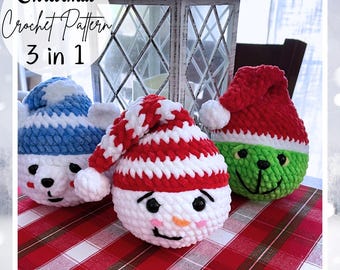 May include: Three crocheted Christmas ornaments: a snowman with a red and white striped hat, a green Grinch with a red Santa hat, and a blue and white polar bear. The ornaments are on a red and white checkered tablecloth.