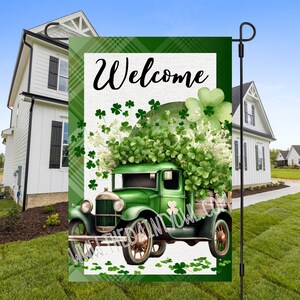 May include: A green vintage truck with a bed full of shamrocks and a white sign that says "Welcome". The truck is on a green plaid background with white shamrocks.