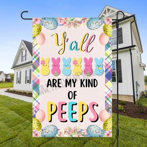 Peut inclure: Un drapeau de jardin rose et blanc avec un motif floral et le texte "Y'all are my kind of peeps". Le drapeau présente une variété de Peeps et d'œufs de Pâques de couleur pastel.