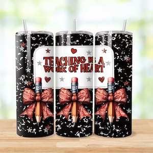 May include: Three black and white stainless steel tumblers with a red pencil and bow design. The tumblers have a black and white notebook paper background with silver glitter stars. The text on the tumblers reads "Teaching is a work of heart".