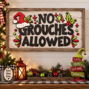 May include: A rectangular wooden sign with a white background and dark brown frame featuring the black text NO GROUCHES ALLOWED, a red Santa hat, and green holly leaves. The sign is decorated with red and green accents and star shapes.