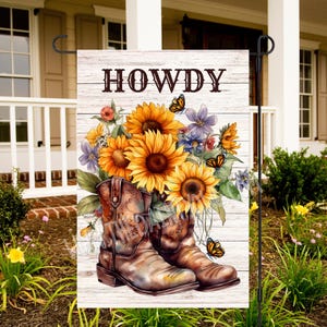 May include: A garden flag with a white wood background featuring a bouquet of sunflowers and wildflowers in brown cowboy boots. The text "HOWDY" is printed in brown at the top of the flag.