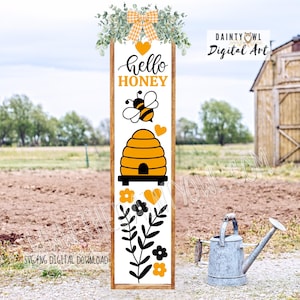 May include: A rectangular wooden sign with a white background features a bee-themed design. The words "hello HONEY" are displayed above a bee and a beehive illustration. The sign is adorned with floral and heart accents, and a gingham bow.