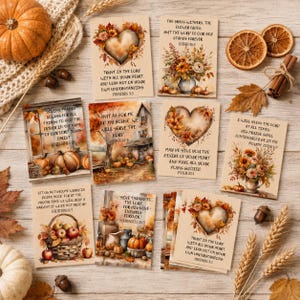 May include: A collection of rectangular cards featuring autumn-themed illustrations of pumpkins, sunflowers, and hearts, each printed with religious scripture verses. The cards are arranged on a wooden surface alongside dried orange slices and wheat.