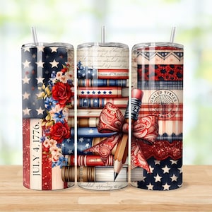 May include: Three patriotic-themed tumblers with straws. Designs include American flags, floral arrangements, stacks of books, a pencil, and a red bow. One tumbler has the text "JULY 4, 1776." Another has the text "States of America" and "UNITED STATES OF AMERICA."