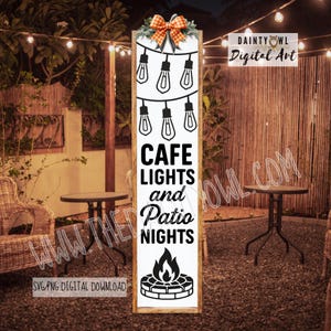 Könnte beinhalten: Vertikales Holzschild mit den Worten "CAFE LIGHTS and Patio NIGHTS" in Schwarz. Das Schild zeigt eine Lichterkette und eine Lagerfeuergrafik. Oben befindet sich eine dekorative Schleife. Der Hintergrund zeigt eine Terrasse.