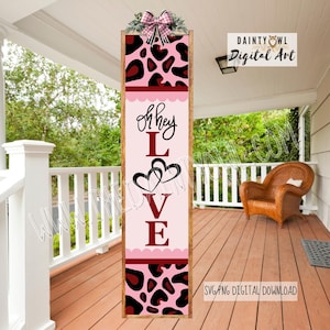 May include: A vertical wooden sign with a pink and red leopard print design and the words "Oh hey LOVE". The sign is decorated with a bow and greenery at the top, and is displayed on a porch.
