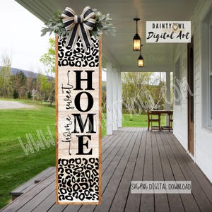 Può includere: Un cartello verticale in legno con un motivo leopardato nella parte superiore e inferiore e la parola "HOME" in grandi lettere nere. Le parole "home sweet" sono scritte verticalmente sul lato sinistro. Il cartello è decorato con un fiocco e vegetazione.