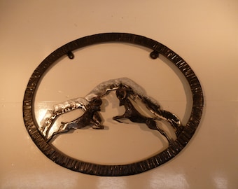 Unique hand forged Rought Iron Sculpture of two charging Rams with mountains in background set in hammer textured oval frame