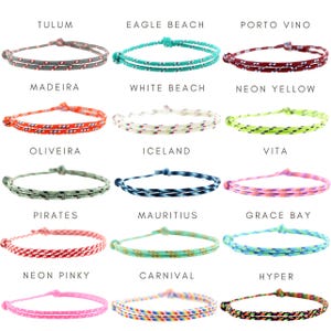 May include: A collection of fifteen thin, adjustable cord bracelets in various colors and patterns, each labeled with names including Tulum, Eagle Beach, Porto Vino, Madeira, White Beach, Neon Yellow, Oliveira, Iceland, Vita, Pirates, Mauritius, Grace Bay, Neon Pinky, Carnival, and Hyper.