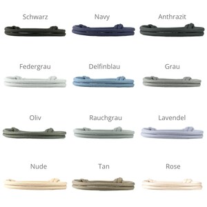 May include: Twelve different color options for a double-layered rope bracelet. The colors are: Schwarz, Navy, Anthrazit, Federgrau, Delfinblau, Grau, Oliv, Rauchgrau, Lavendel, Nude, Tan, and Rose.