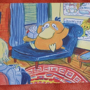 May include: A cartoon illustration of a yellow duck-like creature sitting on a blue couch with a box of tissues. The creature is crying and has a sad expression. The couch is in a room with a yellow wall and a red rug. The text "JANUARY BLUES" is written on the wall.