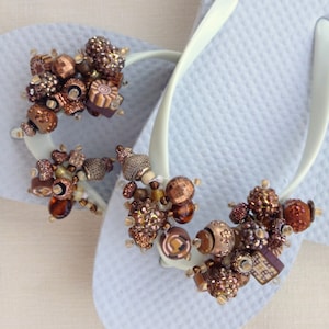 Bronze and Brown Beads on White Flip Flops.