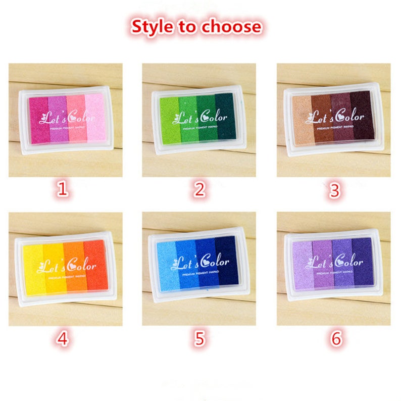 May include: Six different colored ink pads with the text "Let's Color" on each. The ink pads are arranged in two rows of three. The colors are pink, green, brown, orange, blue, and purple.
