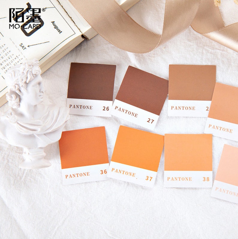 May include: A set of eight color swatches, labeled with Pantone numbers, ranging from brown to orange. The swatches are arranged in two rows of four, with the brown swatches on top and the orange swatches on the bottom.