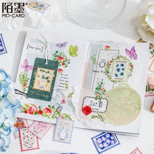 May include: A collection of colorful floral and botanical themed stickers and washi tape. The stickers feature flowers, butterflies, and text like "For You" and "Best Wishes".