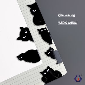 K&ouml;nnte beinhalten: Schwarze, katzenf&ouml;rmige B&uuml;roklammern mit wei&szlig;en Augen. Die B&uuml;roklammern sind vertikal auf einer linierten Notizbuchseite angeordnet. Der Text "You are my MEOW MEOW" ist in schwarzer Tinte auf der Seite geschrieben.
