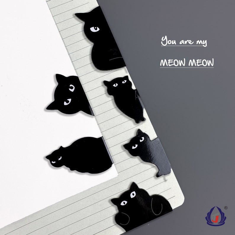 K&ouml;nnte beinhalten: Schwarze, katzenf&ouml;rmige B&uuml;roklammern mit wei&szlig;en Augen. Die B&uuml;roklammern sind vertikal auf einer linierten Notizbuchseite angeordnet. Der Text "You are my MEOW MEOW" ist in schwarzer Tinte auf der Seite geschrieben.
