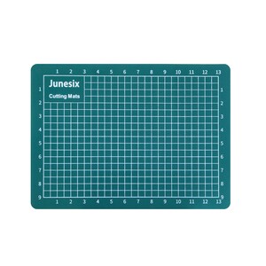 May include: A green self-healing cutting mat with a grid pattern and numbered rows and columns. The mat is labeled "Junesix Cutting Mats".