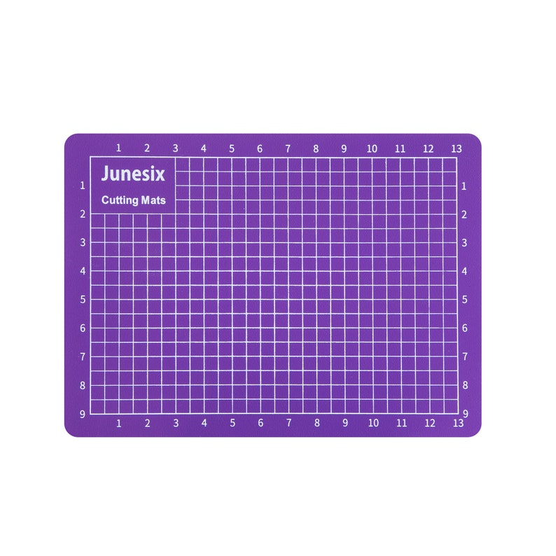 May include: Purple self-healing cutting mat with a grid pattern and numbered rows and columns. The mat is labeled "Junesix Cutting Mats".