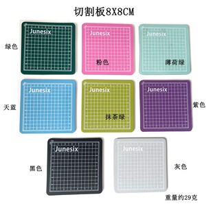 May include: Nine self-healing cutting mats in various colors, including green, pink, light blue, light green, purple, black, and gray. Each mat is 8 inches by 8 inches and features a grid pattern. The mats are labeled with the brand name "Junesix" and the color name in Chinese characters. The text "切割板 8X8CM" is at the top of the image, which translates to "Cutting Board 8X8CM".