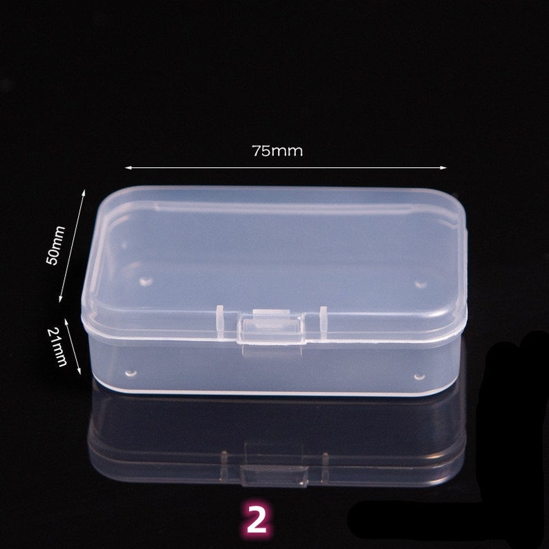May include: A clear plastic storage box with a hinged lid. The box measures 75mm by 50mm by 21mm.