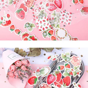 K&ouml;nnte beinhalten: Eine Blatt mit bunten Aufklebern mit Illustrationen von Erdbeeren, Bl&auml;ttern und K&ouml;rben. Die Aufkleber befinden sich auf einem rosa Hintergrund.