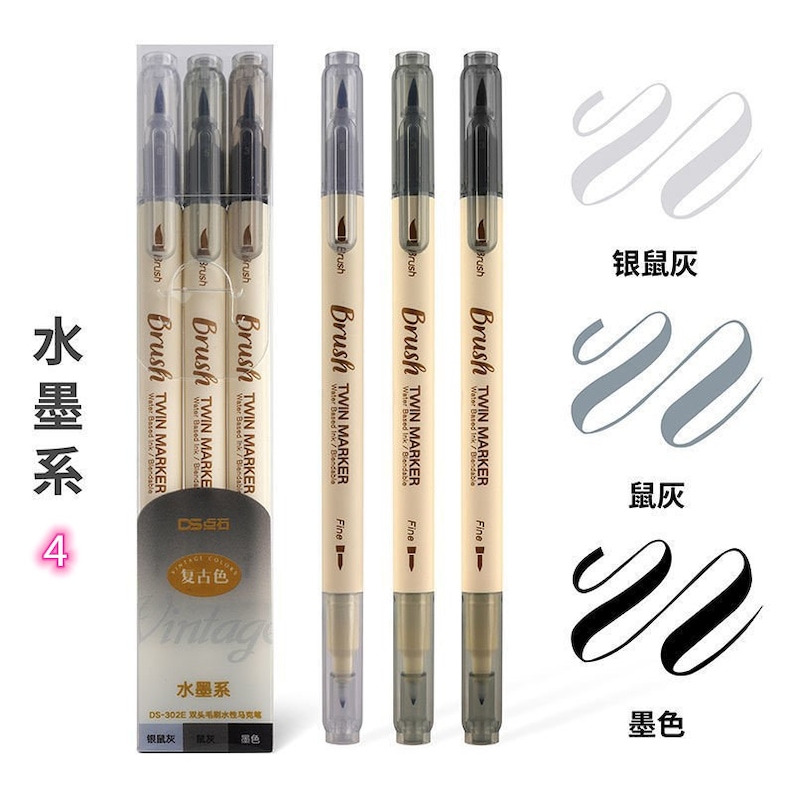 May include: A set of four twin-tip brush markers in a clear plastic package, with three additional markers displayed separately. The markers are beige with black and gray ink. The text on the markers reads "Brush Twin Marker". The image also shows ink swatches.