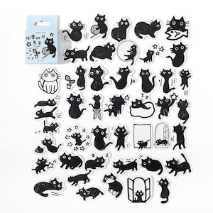 May include: A sheet of black and white stickers featuring various illustrations of cats in different poses. The stickers are on a white background. The text on the sticker sheet reads "快乐生活" which translates to "Happy Life".