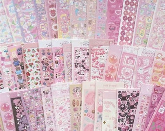 Peut inclure: Une collection de feuilles d'autocollants roses et blanches avec divers motifs, notamment des animaux, des fleurs, des cœurs et des lettres. Les autocollants sont parfaits pour décorer les agendas, les journaux et autres projets d'artisanat.
