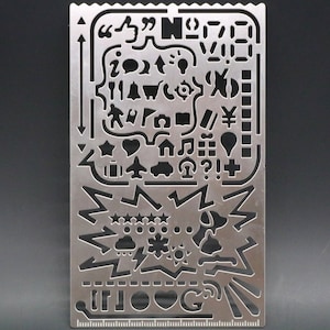 May include: A metal stencil with various shapes and symbols, including a thumbs up, a light bulb, a heart, a star, a house, a music note, a question mark, an exclamation point, a plus sign, and a lightning bolt. The stencil also includes the words "IF YOU" and "G".