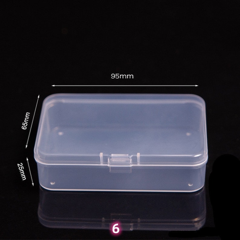 May include: Clear plastic storage box with a hinged lid. The box measures 95mm by 65mm by 25mm.