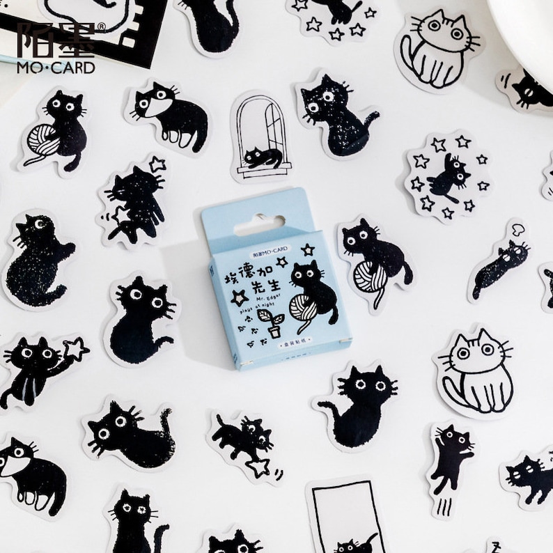 May include: A sheet of black and white stickers featuring cats and stars. The stickers are on a white background. The text on the sticker box reads "Edgar ☆ Mr. Cool at night".