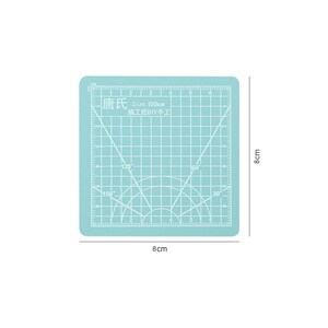 May include: A light blue self-healing cutting mat with a grid pattern and a protractor. The mat is 8 inches by 8 inches and has the text "唐氏 Size:8X8cm 姚工匠DIY手工" printed on it.
