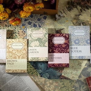 Peut inclure: Plusieurs blocs de papier décoratif avec des motifs floraux et botaniques. Les titres des blocs sont "Brown Page", "Green Garden", "Red Old Days" et "Blue Totem". Les couleurs dominantes sont le marron, le vert, le rouge et le bleu.