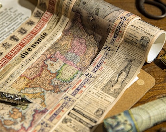 May include: Decorative vintage washi tape rolls featuring a world map, sheet music, and newspaper clippings. The tape includes text such as "FRAGILE" and "ICE COUPON". The tape is on a wooden surface.