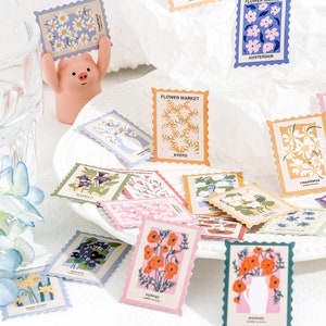 May include: A set of colorful floral patterned stickers with a scalloped edge. The stickers feature various flowers, including poppies, daisies, and bluebells. The stickers are perfect for adding a touch of whimsy to journals, planners, and other craft projects.