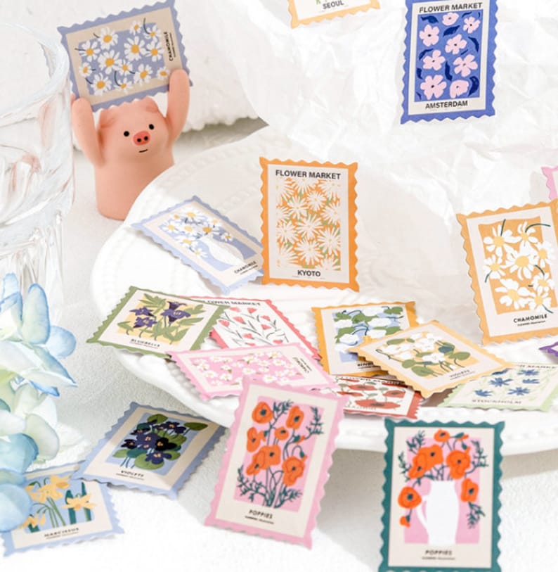 May include: A set of colorful floral patterned stickers with a scalloped edge. The stickers feature various flowers, including poppies, daisies, and bluebells. The stickers are perfect for adding a touch of whimsy to journals, planners, and other craft projects.