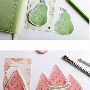 May include: Two sets of colorful sticky notes featuring watercolor illustrations of fruit. The first set has two green pears with brown stems and leaves. The second set has four red watermelon slices with green rinds.