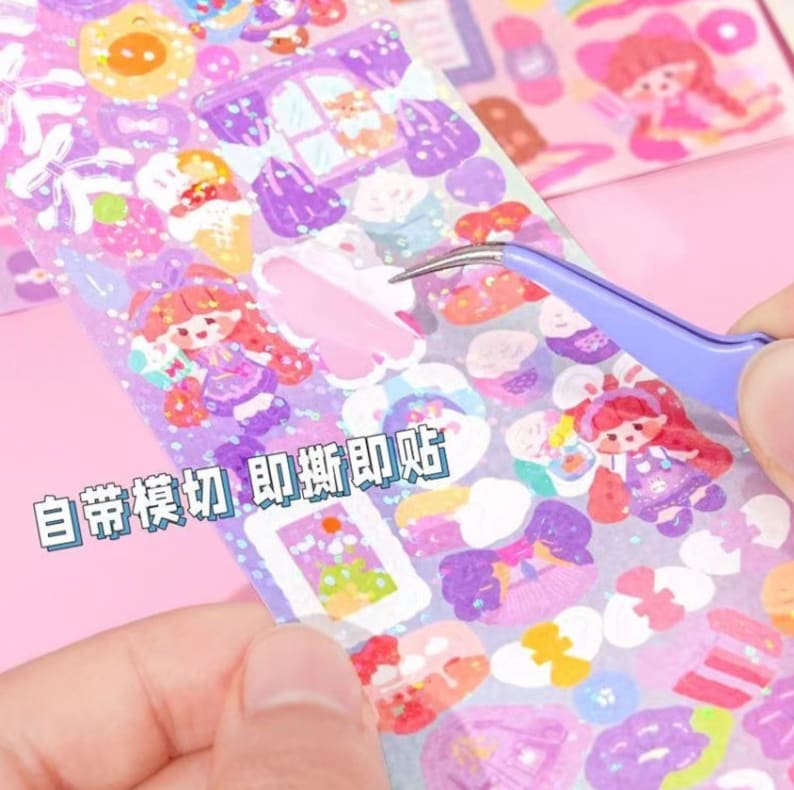 May include: A sheet of colourful stickers featuring cartoon characters, hearts, and other cute designs. The stickers are on a clear sheet with a glittery finish. The text "自帶裁切 即撕即貼" is printed on the sheet.